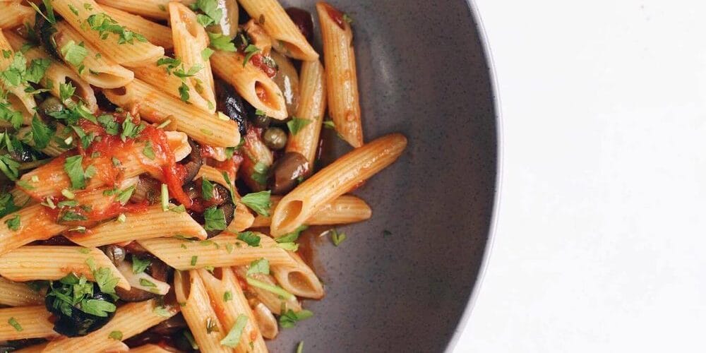 Penne De Cecco “Puttanesca” with garlic, parsley, tomato, anchovies, marinated olives and capers.