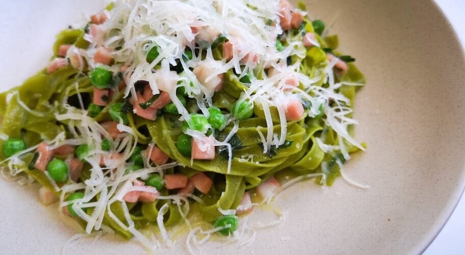 Spinach Egg Tagliatelle with mortadella, peas and aged goat cheese