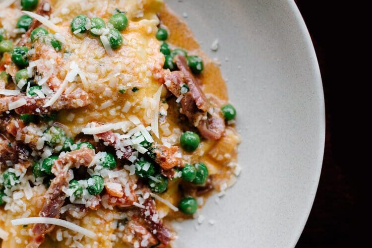 Bertagni Tomato and Mozzarella Ravioli “Papalina”, with prosciutto, peas, our secret tomato sauce and cream.